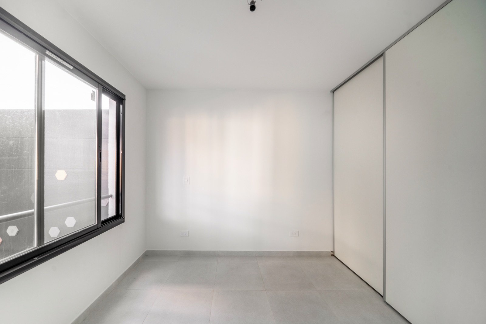 Dormitorio con placard integrado y ventana